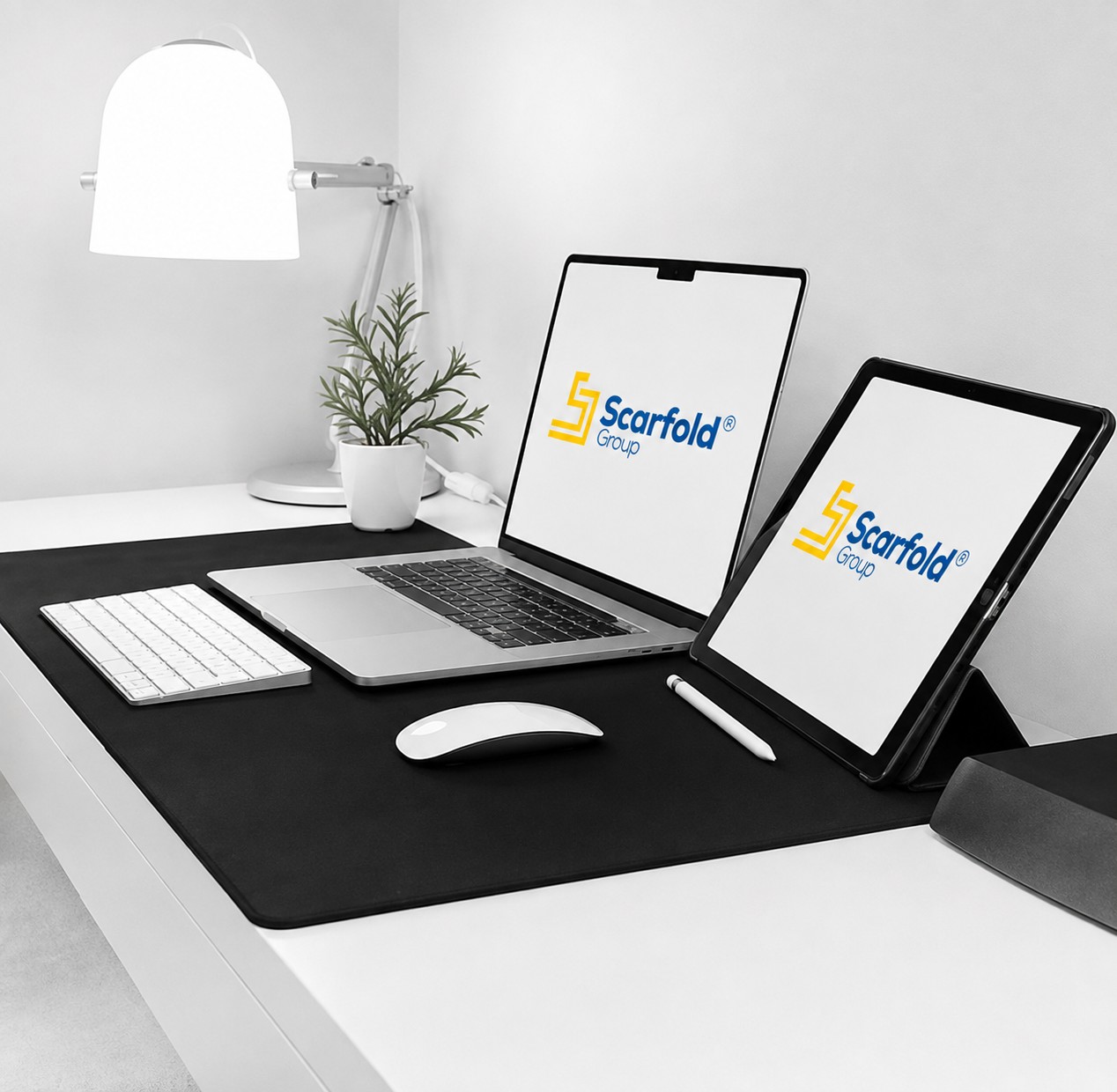 A Scarfold Group workstation, with the Scarfold Group logo on the laptop and tablet screens.